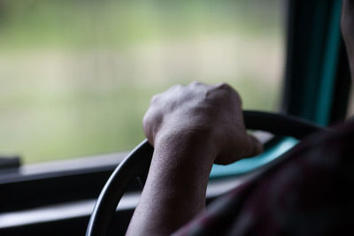 Cropped image of person driving car