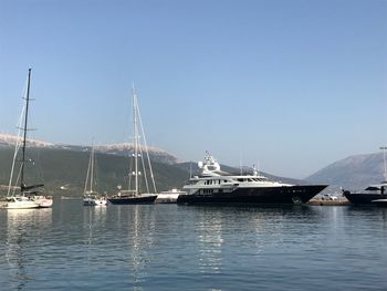 Boats sailing in sea against clear sky