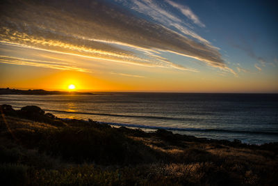 Scenic view of beach against sky during sunset