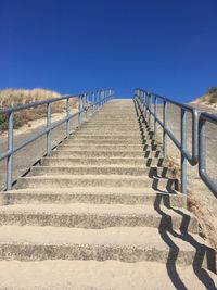 Staircase leading to built structure against clear blue sky