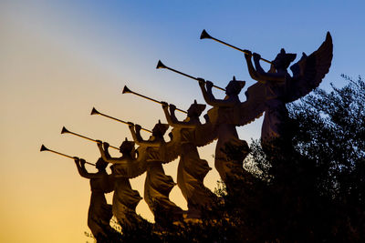 Low angle view of statue against clear sky during sunset