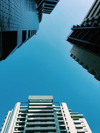 Low angle view of modern buildings against clear blue sky