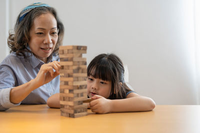 Mother and daughter playing jenga at home