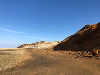 Scenic view of desert against clear blue sky