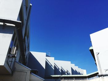 Low angle view of buildings against clear blue sky