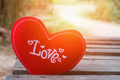 Close-up of red heart shape in wooden table