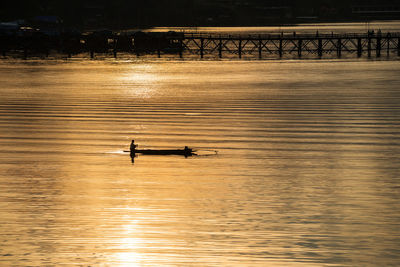 High angle view of silhouette person on boat in river during sunset