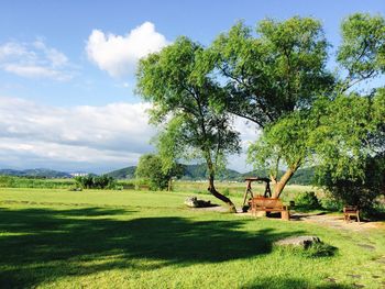 Scenic view of grassy field against cloudy sky