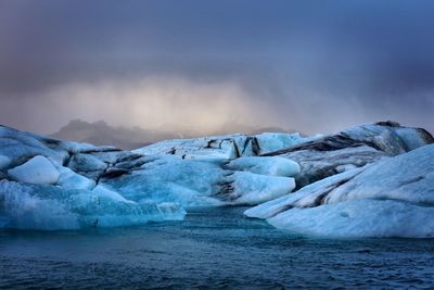 Scenic view of frozen lake against sky during sunset