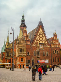 People walking footpath by wroclaw town hall