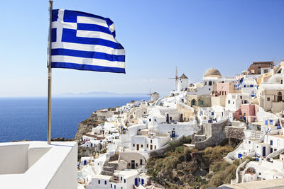 Close-up of greek flag by sea against clear sky