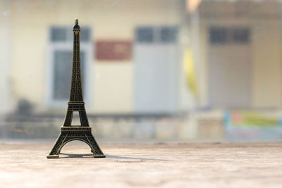 Close-up of metallic structure on table against wall