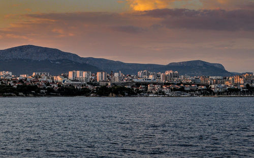 Scenic view of sea by town against sky