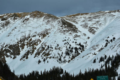 Low angle view of snowcapped mountains against sky