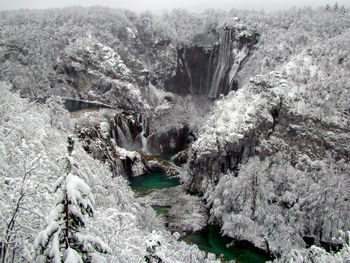 High angle view of frozen waterfall amidst trees in forest