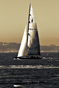 Sailboat in sea against clear sky