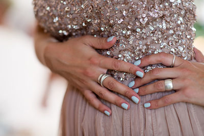 Midsection of woman showing her nail polish on fingernails