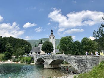 Arch bridge over river against buildings