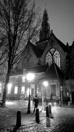 People walking in illuminated cathedral at night