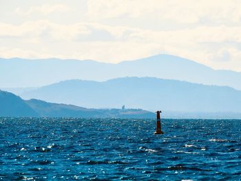 Man standing in sea against sky