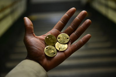 Close-up of cropped hand holding metal badges