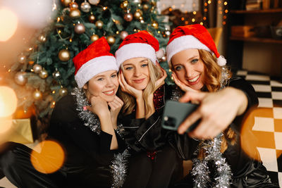 Happy funny girls celebrate christmas holidays and new year in a cozy house