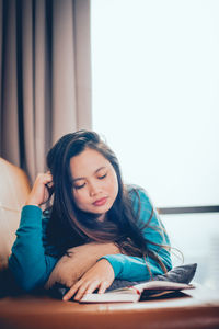 Young woman looking at camera while sitting on table