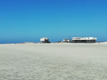 Built structure on beach against clear blue sky