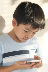 Close-up of boy using mobile phone