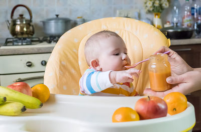 High angle view of cute baby boy eating food at home