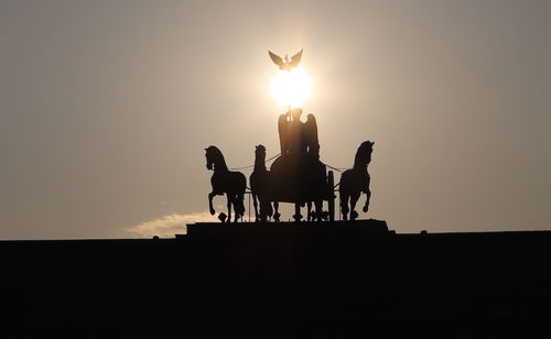 Silhouette people standing against sky during sunset