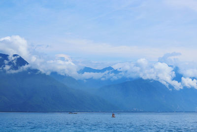 Scenic view of sea and mountains against sky