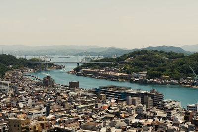 High angle view of bay and buildings against clear sky