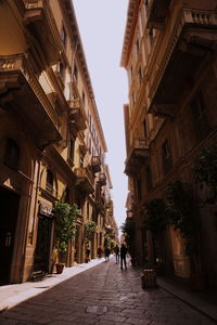 People walking on street amidst buildings in city