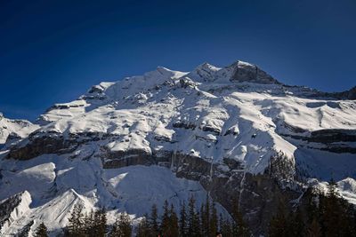 Scenic view of snowcapped mountains against clear blue sky