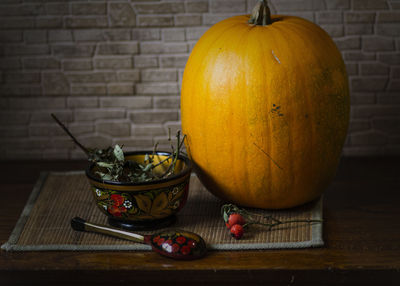 Close-up of pumpkin on table against wall