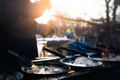 Midsection of person preparing food during sunset