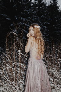 Woman standing by tree in forest