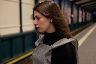 Close-up of young woman standing against wall