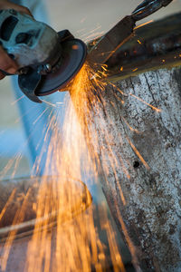 Cropped hand of worker cutting iron rod at industry