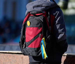 A yellow-blue ribbon is tied on a man's backpack, november 2022 kherson