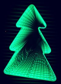 Close-up of illuminated lighting equipment against black background