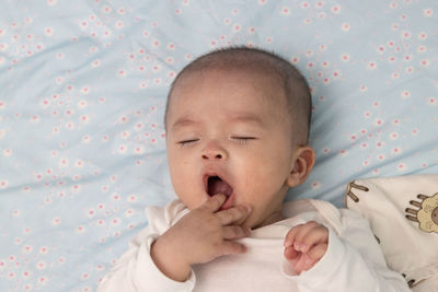 Cute baby girl lying on bed