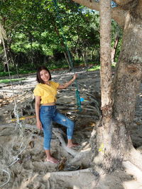 Portrait of a smiling woman standing against trees