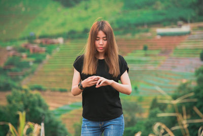 Young woman standing on agricultural field