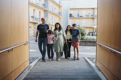 Family standing in courtyard of residential neighborhood