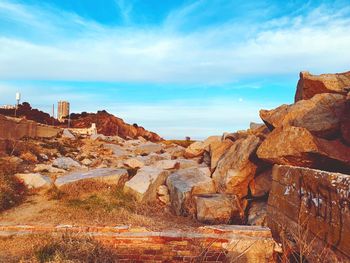 Rock formations by sea against sky