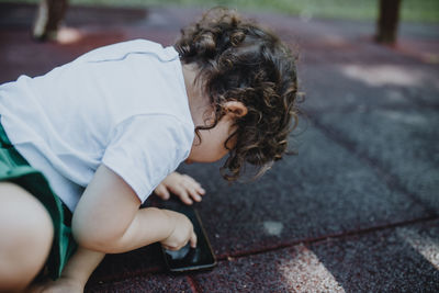 High angle view of girl using smart phone on road