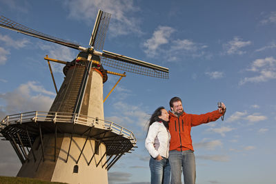 Mature couple taking selfie with windmill in the netherlands