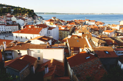 Red roofs of old town piran with main church against the sunrise sky, adriatic sea. slovenia